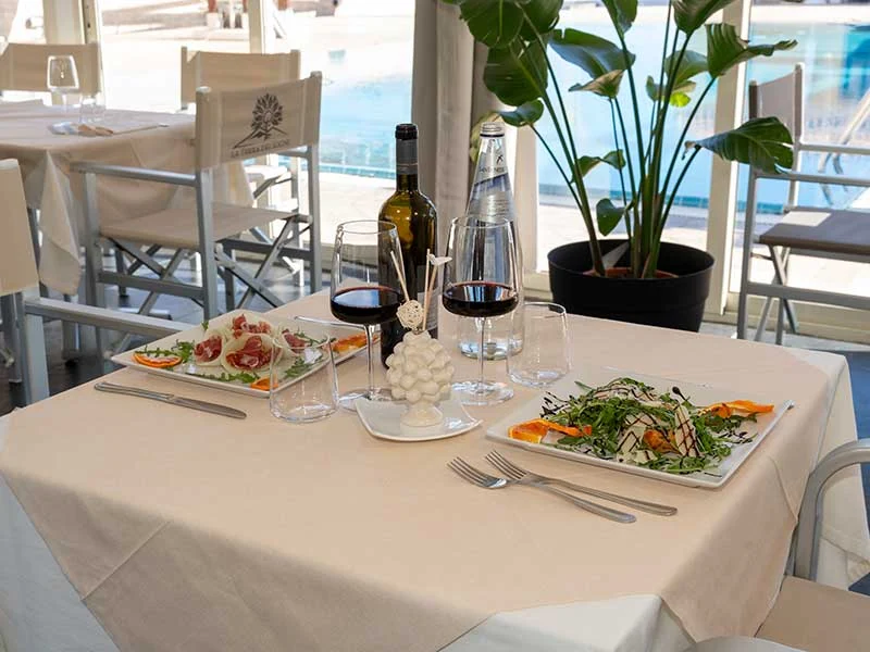 Tavola con piatti e vino nel ristorante La Terra dei Sogni